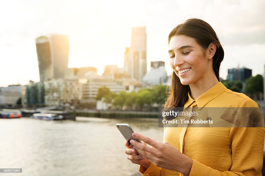 Woman using mobile at sunset