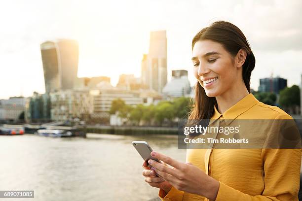woman using mobile at sunset - summer in the city stock pictures, royalty-free photos & images