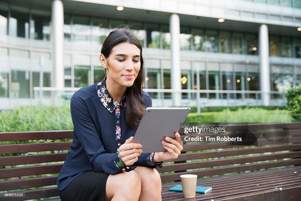 Woman on bench using tablet
