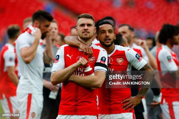 Arsenal's Welsh midfielder Aaron Ramsey and Arsenal's English midfielder Theo Walcott celebrate on the pitch after their win over Chelsea in the...