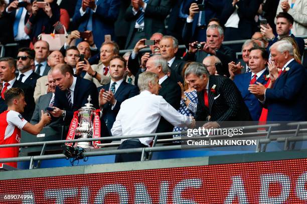 Arsenal's US owner Stan Kroenke shakes hands with Arsenal's French manager Arsene Wenger as Arsenal players celebrate their victory over Chelsea in...