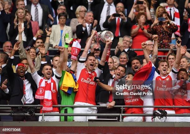 Aaron Ramsey, Per Mertesacker, Laurent Koscielny, Alexis Sanchez and Rob Holding of Arsenal lift the FA Cup Trophy after the match between Arsenal...