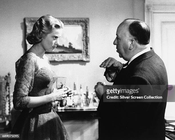 American actress Grace Kelly talking to director Alfred Hitchcock on the set of the film 'Dial M for Murder', 1954.