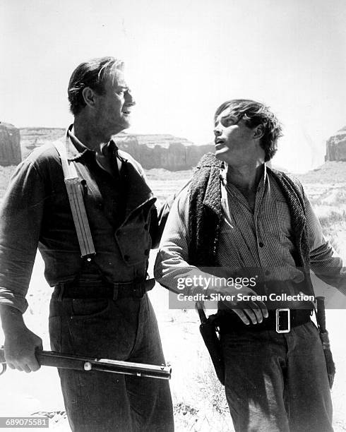 John Wayne as Ethan Edwards and Jeffrey Hunter as Martin Pawley in the western 'The Searchers', directed by John Ford, 1956.