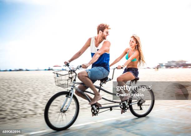 couple riding tandem bicycle in la - tandem stock pictures, royalty-free photos & images