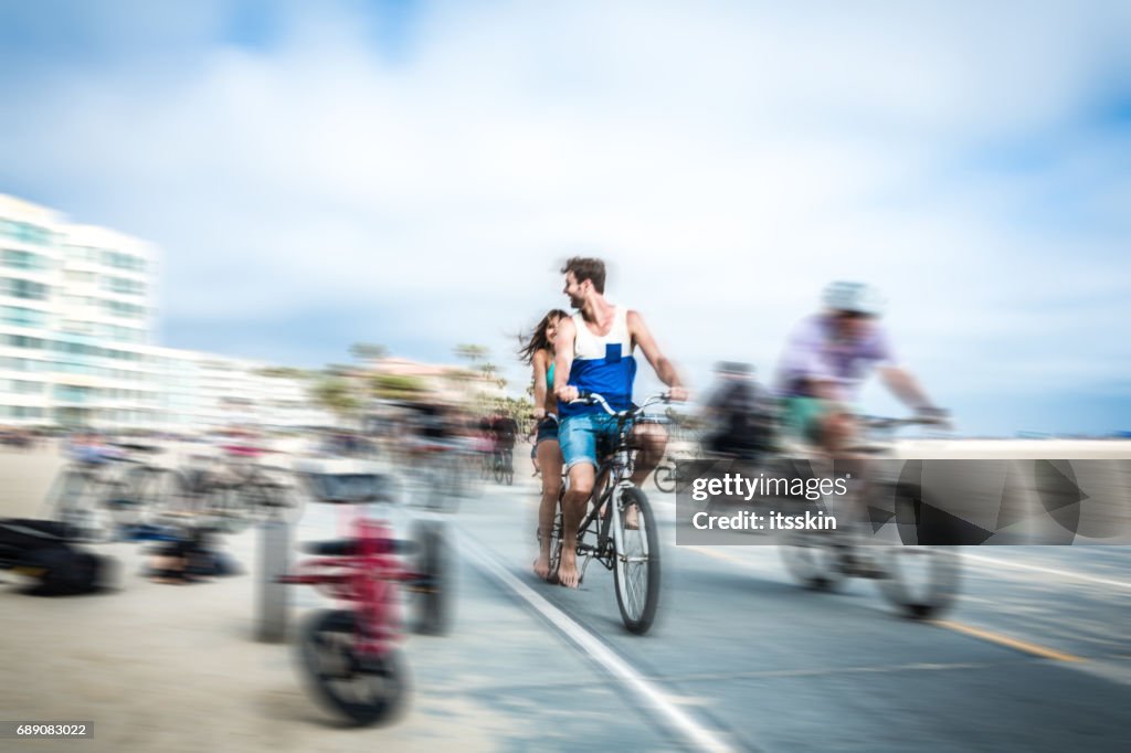 Couple riding tandem bicycle in LA. Blurred motion