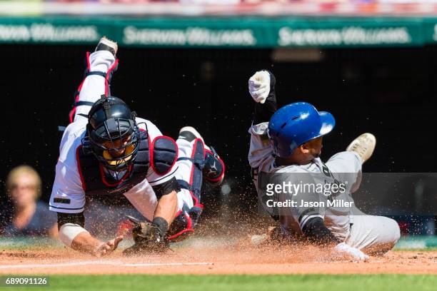 Catcher Yan Gomes of the Cleveland Indians tries to tag Alcides Escobar of the Kansas City Royals as he scores on a sacrifice fly by Salvador Perez...