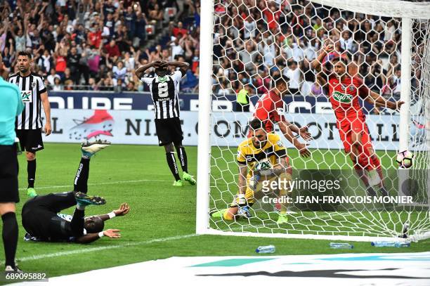 Angers' French defender Issa Cissokho falls as Angers' French goalkeeper Alexandre Letellier and Paris Saint-Germain's Brazilian defender Marquinhos...