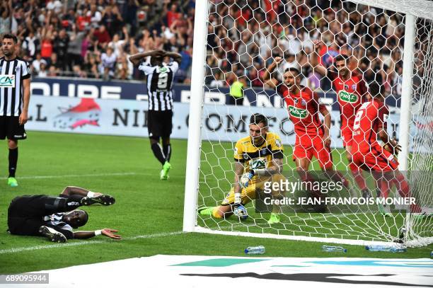 Angers' French defender Issa Cissokho falls as Angers' French goalkeeper Alexandre Letellier and Paris Saint-Germain's players react after he scored...
