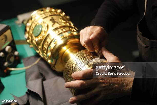 The DFB Cup trophy is being engraved prior to the awarding ceremony after the DFB Cup Final 2017 between Eintracht Frankfurt and Borussia Dortmund at...