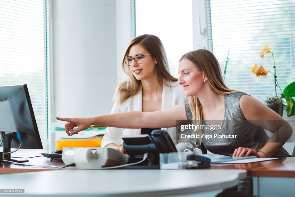 Young adult woman using computer, young woman pointing