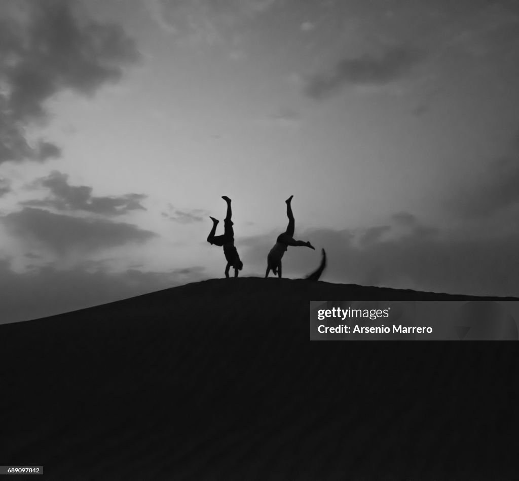 Silhouette Of Young Man Jumping in a dune in Mahmid Morocco