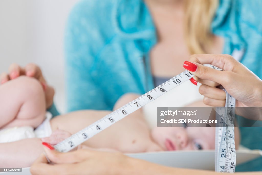 Nurse measures baby's head circumference