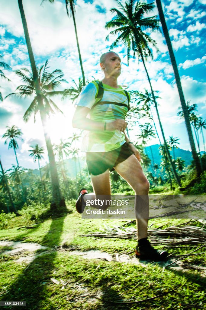 Um homem correndo na floresta tropical