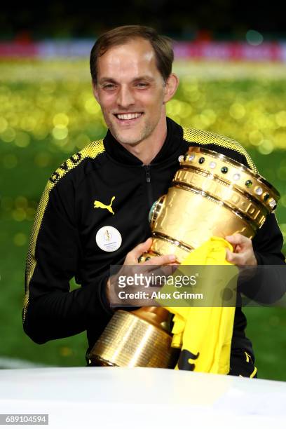 Thomas Tuchel of Dortmund smiles while holding the trophy after winning the DFB Cup final match between Eintracht Frankfurt and Borussia Dortmund at...