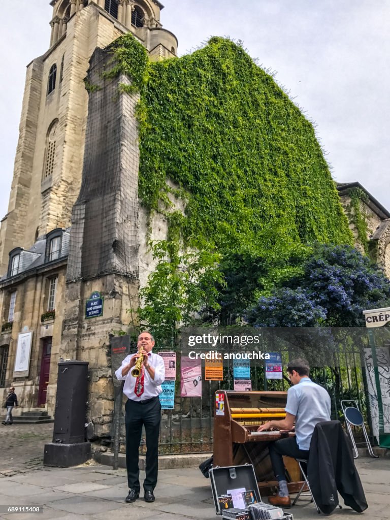 Músico callejero tocando música cerca de Saint Germain des pres Church, París, Francia