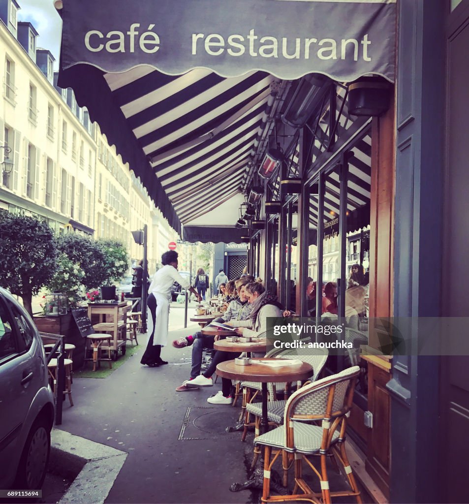 Pessoas lá fora a comer no café de Paris, França