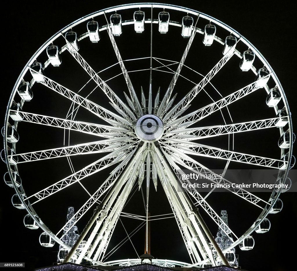 Ferris wheel illuminated at night, front view
