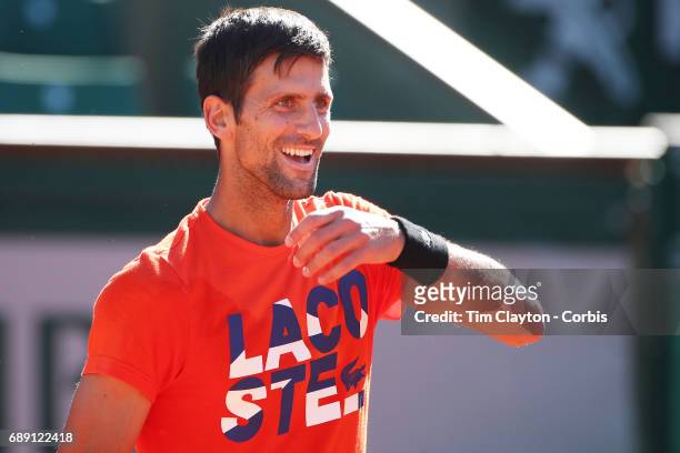 French Open Tennis Tournament - Novak Djokovic of Serbia jokes with his coach Andre Agassi while practicing on Court Philippe-Chatrier in preparation...