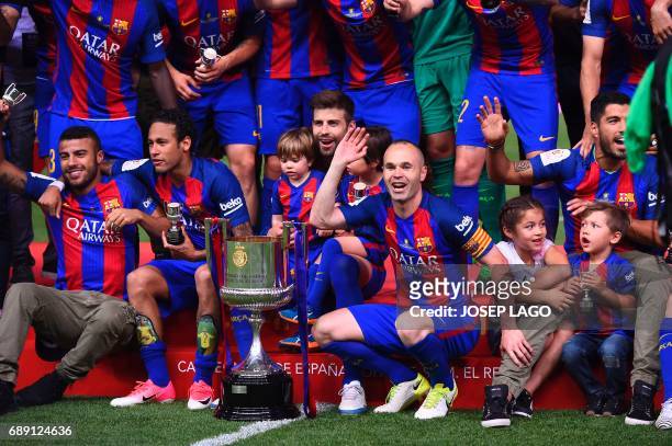 Barcelona's midfielder Andres Iniesta and teammates celebrate their victory past the trophy after the team won the Spanish Copa del Rey final...