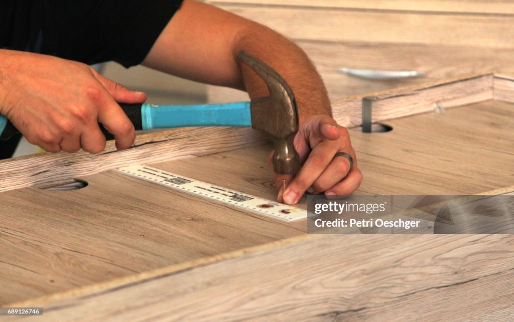 A Young man building a cabinet.