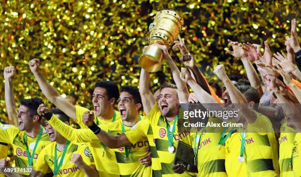 Team captain Marcel Schmelzer of Dortmund lifts the trophy after winning the DFB Cup Final between Eintracht Frankfurt and Borussia Dortmund at...
