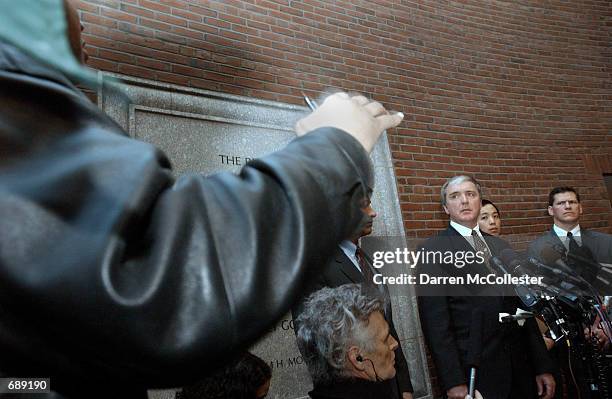 Reporter gestures while asking a question as US Attorney Michael Sullivan, Assistant US Attorney Colin Owyang, and FBI Special Agent in Charge...