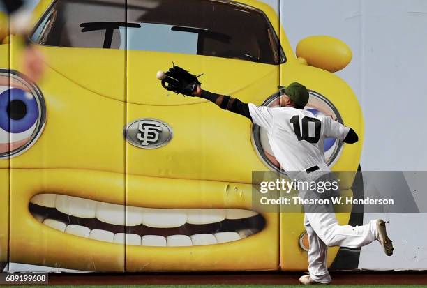 Eduardo Nunez of the San Francisco Giants crashes into the wall as the ball goes off his glove for a double off the bat of Rio Ruiz of the Atlanta...