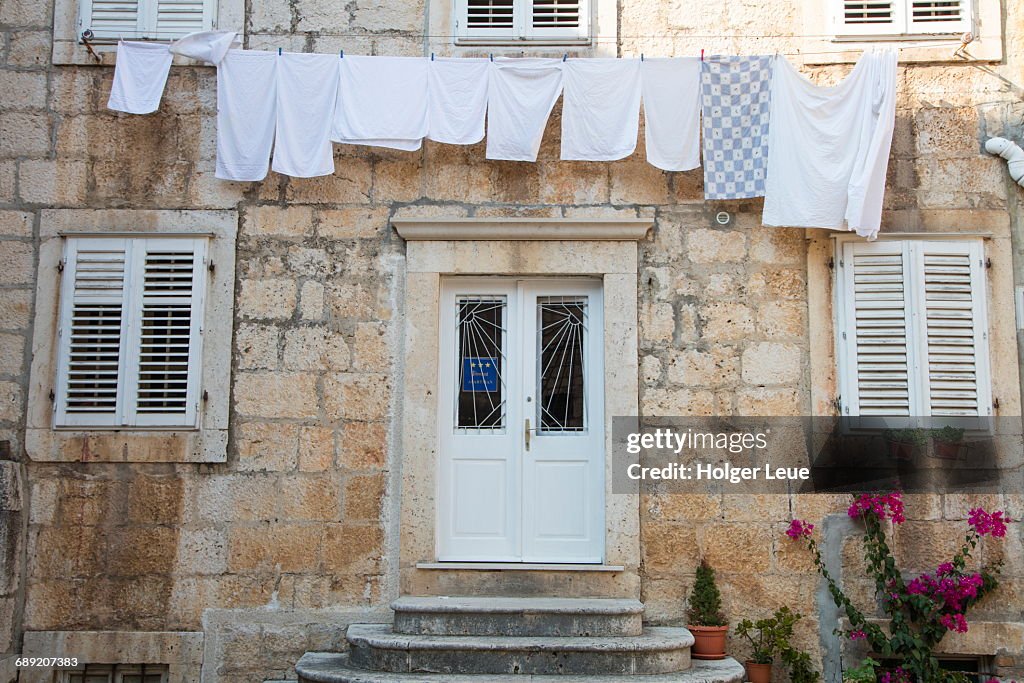 Laundry hangs from clothes line on brick building