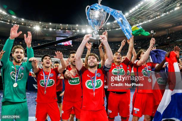 Paris Saint-Germain's Brazilian defender Maxwell holds the trophy as he and teammates celebrate after winning the French Cup final football match...
