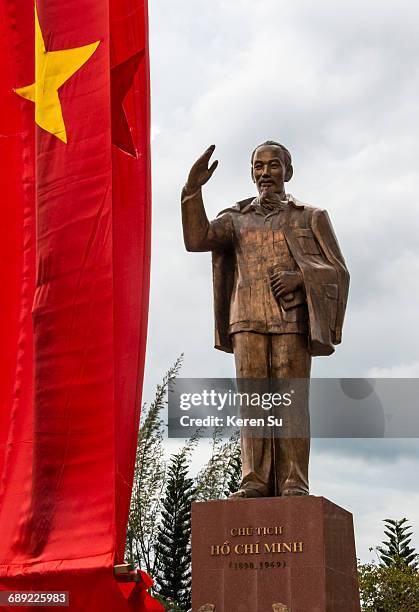 statue of ho chi minh with national flag - ho chi minh photos et images de collection