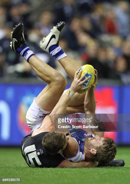 Lachlan Hansen of the Kangaroos is tackled by Sam Docherty of the Blues during the round 10 AFL match between the Carlton Blues and the North...