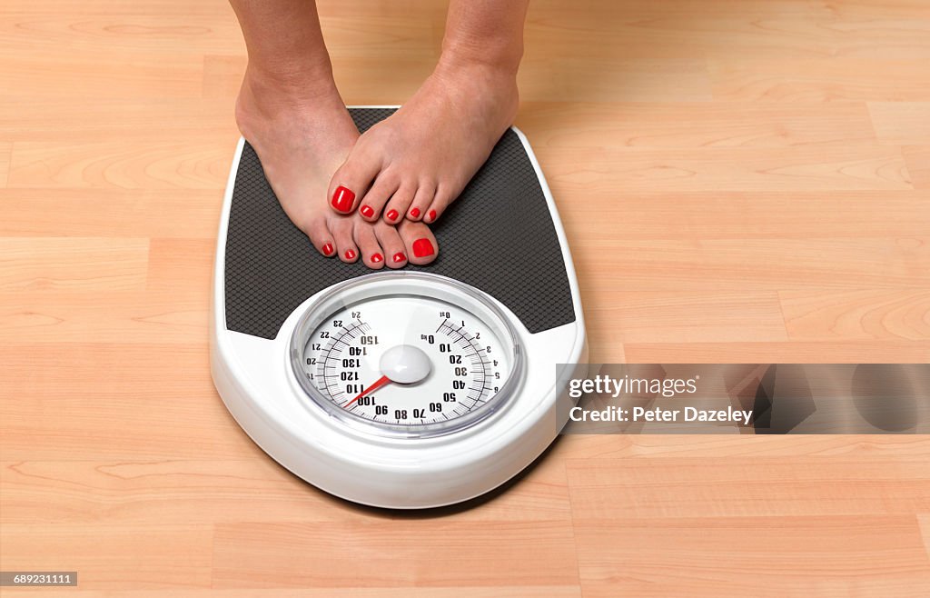 Obese woman weighing herself