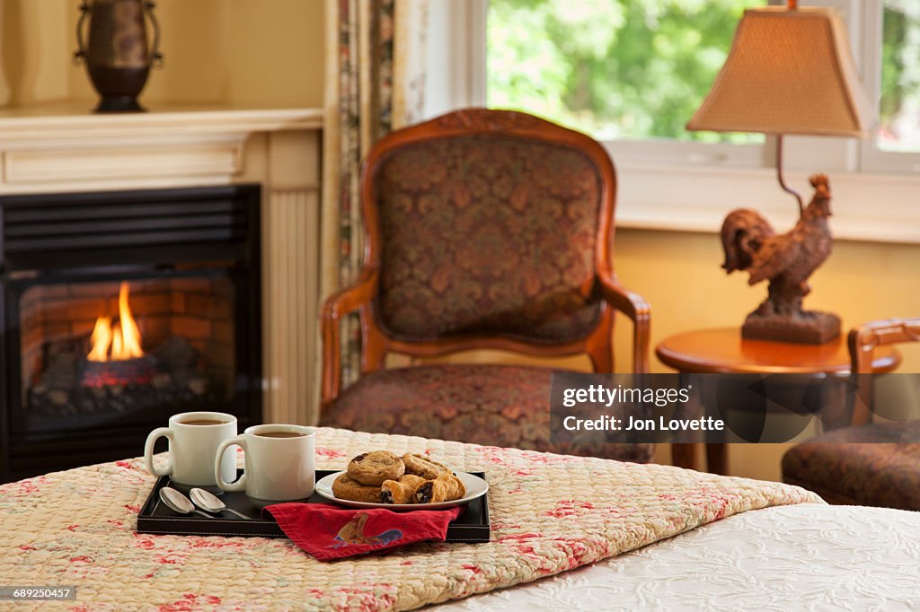Coffee and cookies on bed by fire
