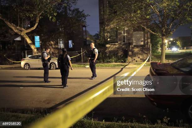 Police investigate the scene of a shooting on May 27, 2017 in Chicago, Illinois. Chicago police have added more than 1,000 officers to the streets...