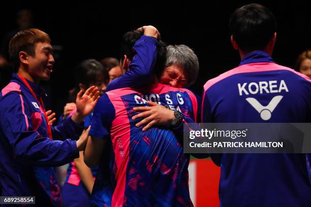 South Korea's head coach Kang Kyung-Jin embraces player Choi Sol-Gyu following the team's victory over China in the team final at the 2017 Sudirman...