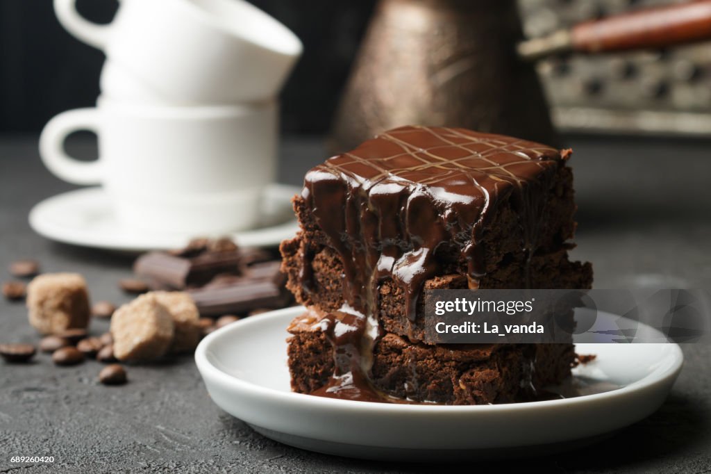 Delicious homemade brownie with chocolate sauce and caramel on the table. Selective focus