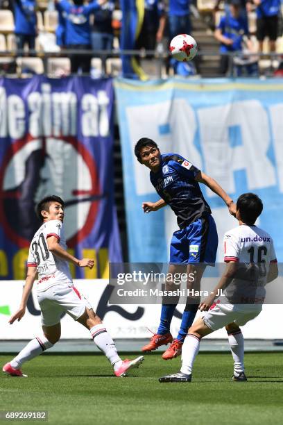 Yoshinori Suzuki of Oita Trinita heads the ball in front of Yuta Toyokawa and Kenji Sekido of Fagiano Okayama during the J.League J2 match between...