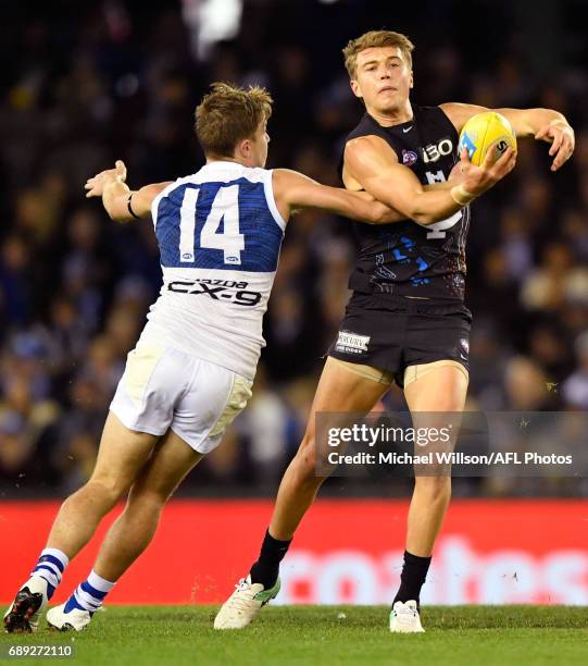 Patrick Cripps of the Blues is tackled by Trent Dumont of the Kangaroos during the 2017 AFL round 10 match between the Carlton Blues and the North...