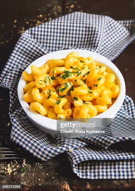 homemade american dish mac and cheese with pumpkin and parsley in a bowl on a wooden table, selective focus - macaroni and cheese stockfoto's en -beelden