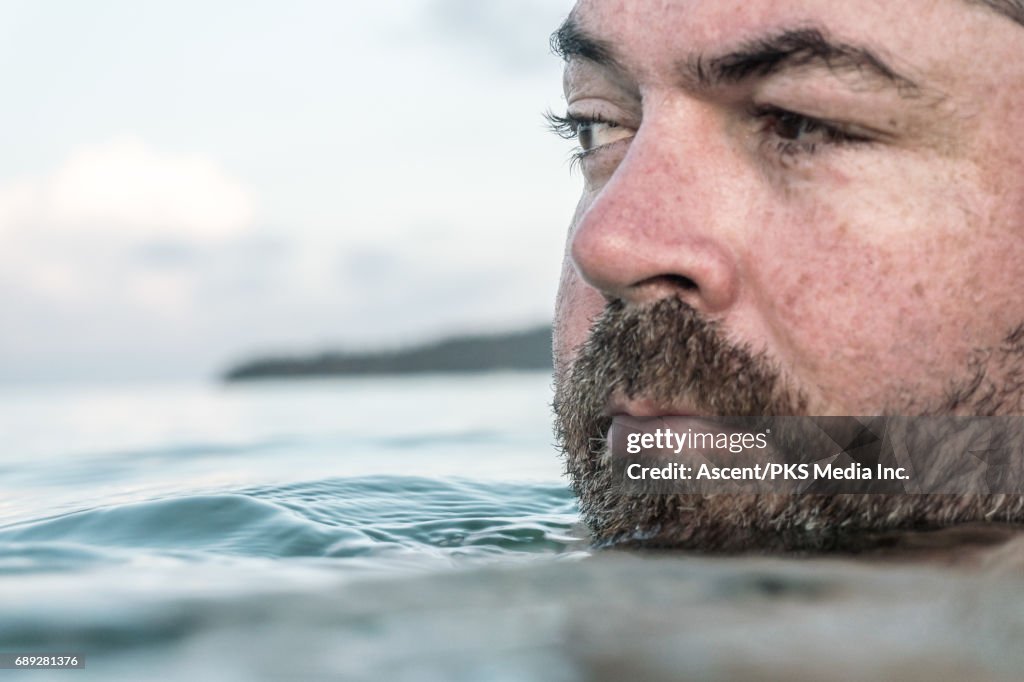 Man floats in tranquil sea, evening light