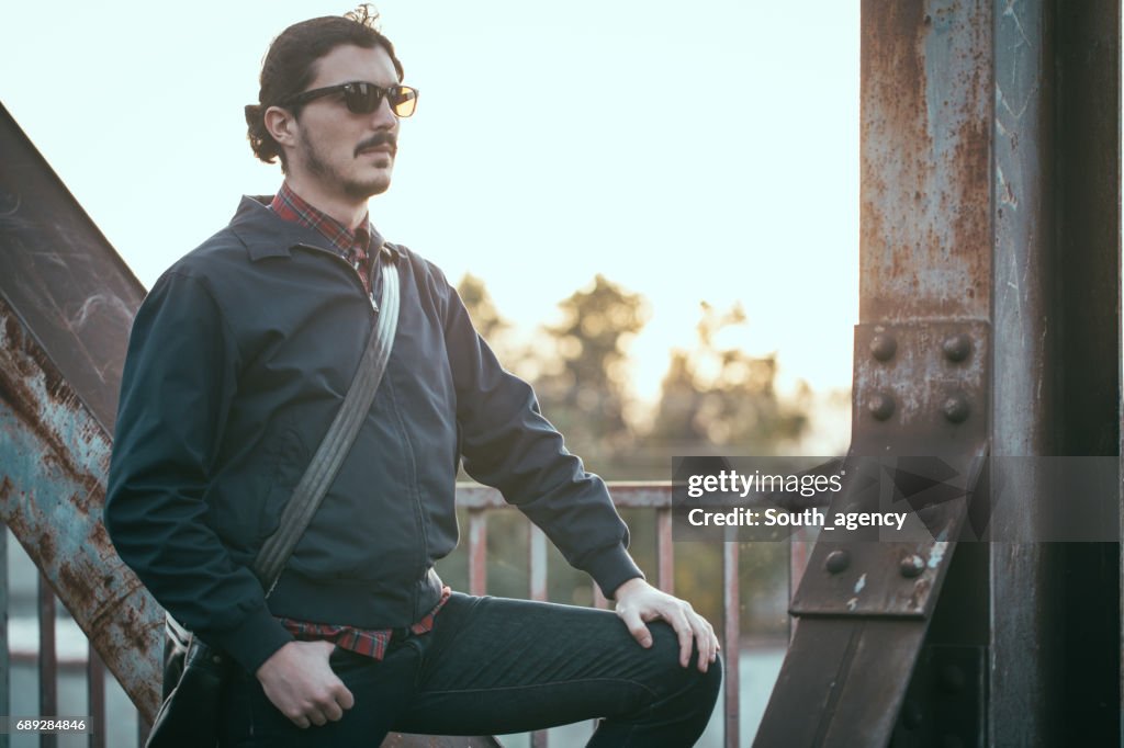 Handsome man standing on the bridge