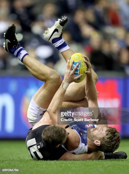 Lachlan Hansen of the Kangaroos is tackled by Sam Docherty of the Blues during the round 10 AFL match between the Carlton Blues and the North...