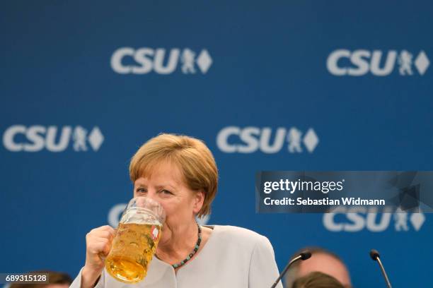 German Chancellor and Chairwoman of the German Christian Democrats Angela Merkel drinks from a beer mug after her speech at the Trudering fest on May...