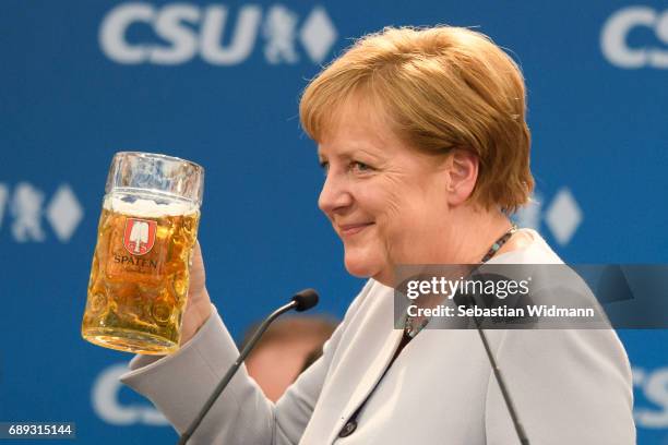 German Chancellor and Chairwoman of the German Christian Democrats Angela Merkel holds a beer mug after her speech at the Trudering fest on May 28,...