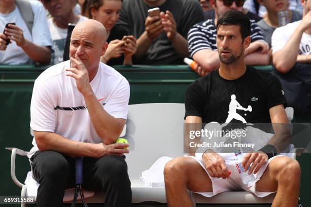 Novak Djokovic of Serbia in discussion with coach Andre Agassi during practice on day one of the 2017 French Open at Roland Garros on May 28, 2017 in...