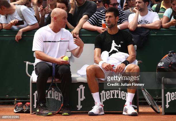Novak Djokovic of Serbia in discussion with coach Andre Agassi during practice on day one of the 2017 French Open at Roland Garros on May 28, 2017 in...