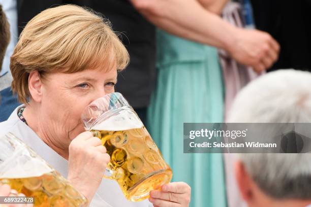 German Chancellor and Chairwoman of the German Christian Democrats Angela Merkel drinks from a beer mug at the Trudering fest on May 28, 2017 in...