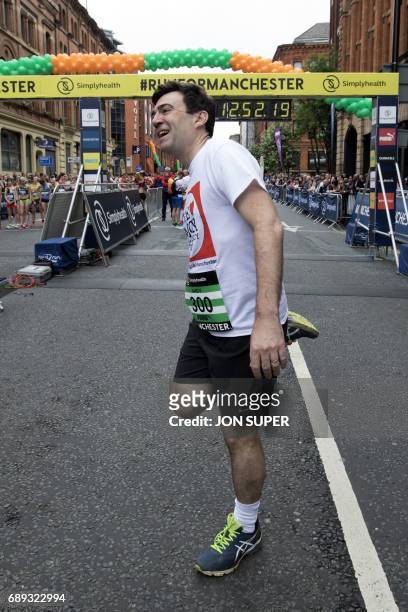 Manchester mayor Andy Burnham does stretching exercises at the start of the Great Manchester Run in Manchester, north west England on May 28, 2017. -...