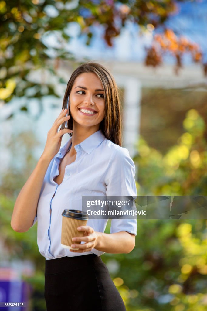 Smart beautiful smiling girl coffee talks on the phone